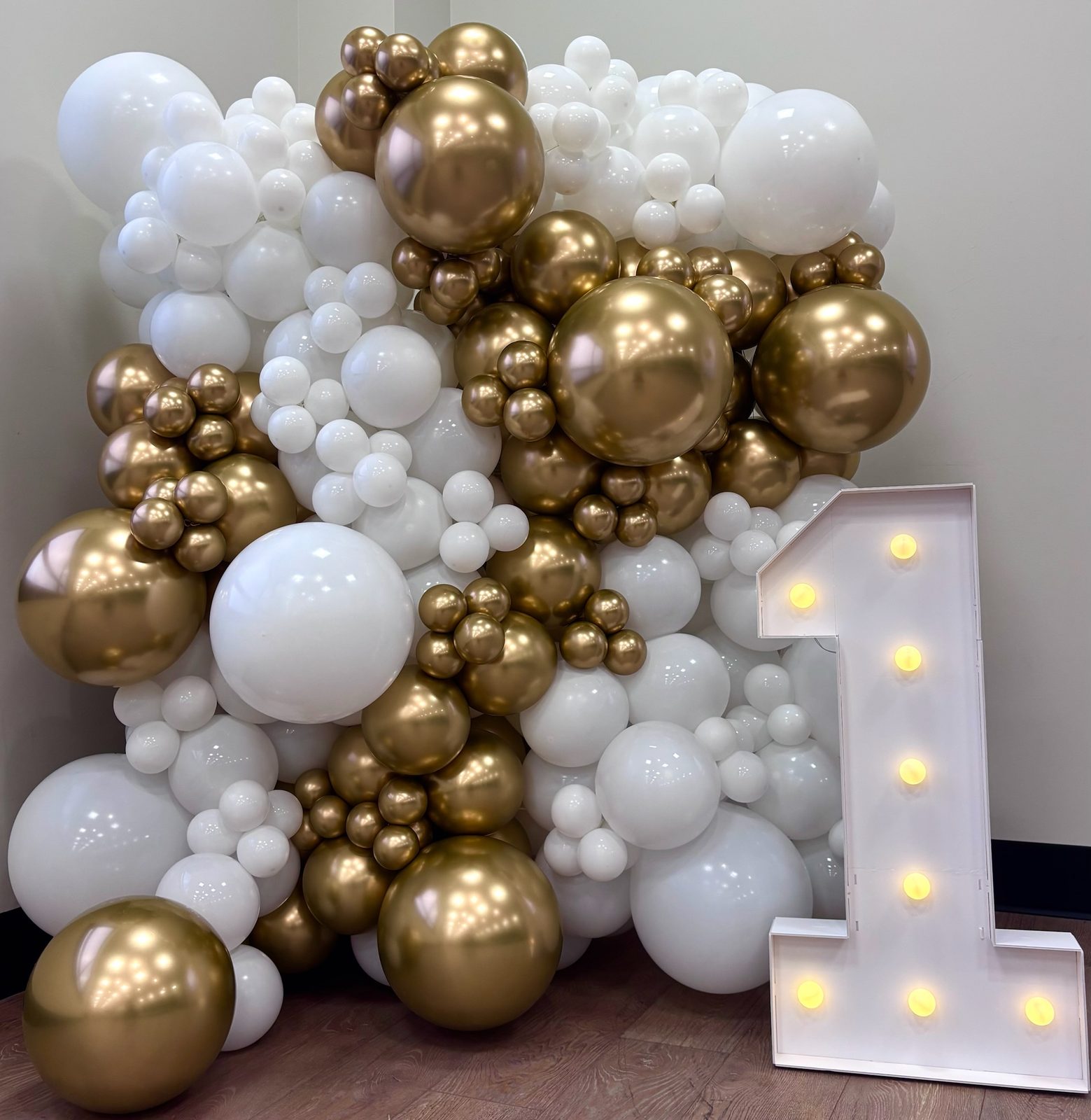 White and chrome gold balloon wall with marquee number one